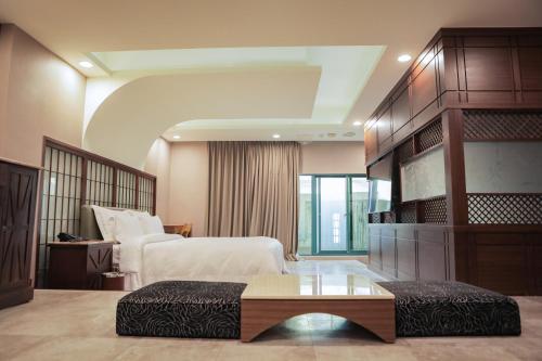 新营欧悦连锁精品汽车旅馆新营馆的酒店客房配有一张床铺和一张桌子。