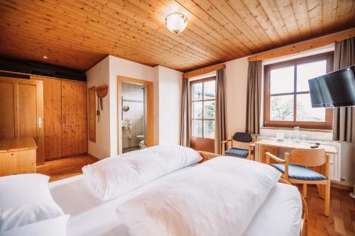 韦因地区拉奇Weinhotel Maitz Wolfgang的一间卧室配有两张白色的床和一张书桌