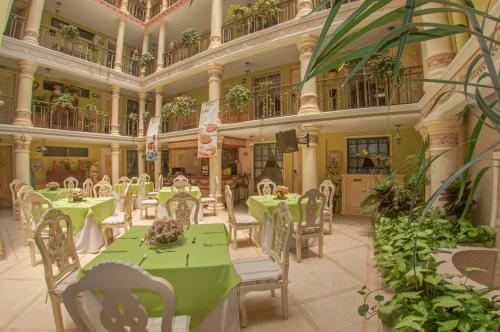 贾拉普拉斯玛格丽特广场水晶别墅的大楼内一家带绿色桌椅的餐厅