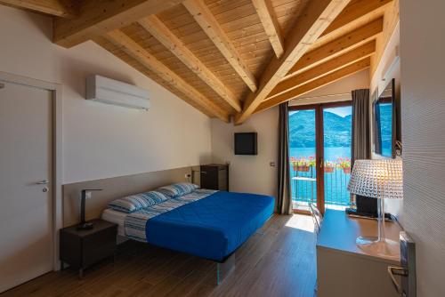 梅纳焦Foresteria Lago di Como的一间卧室配有蓝色的床、一张书桌和窗户。