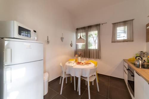 奥库格哥恩基Apartment One的厨房配有白色桌子和白色冰箱。