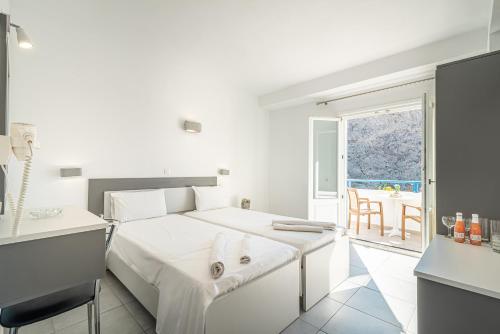 佩里萨Marianna Hotel的白色卧室配有床和桌子