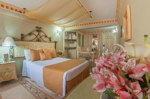 贾拉普拉斯玛格丽特广场水晶别墅的卧室里有一床,鲜花盛开