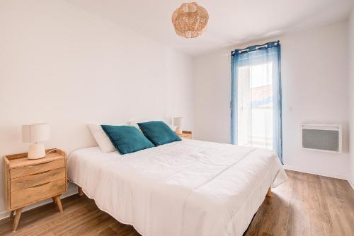 拉卡诺Ressourcez vous dans ce bel appartement a Lacanau的白色的卧室设有一张大床和一个窗户