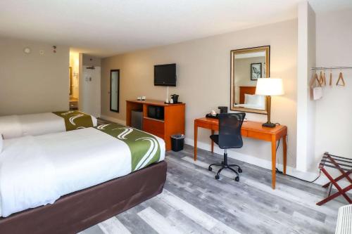 迈阿密Quality Inn Miami Airport - Doral的配有一张床和一张书桌的酒店客房