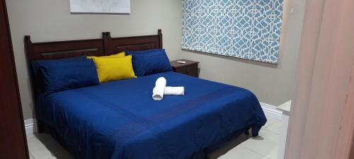 德班2 Sleeper SEA VIEW Apartments - Near MSC Cruise Terminal的一间卧室配有蓝色的床和2条毛巾