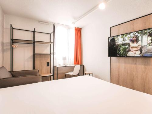 阿维尼翁南阿维尼翁宜必思酒店的一间设有床铺和墙上电视的房间