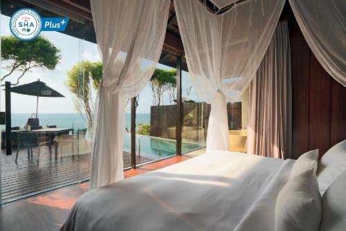 拉迈Silavadee Pool Spa Resort - SHA Extra Plus的一间卧室配有一张床,享有海景
