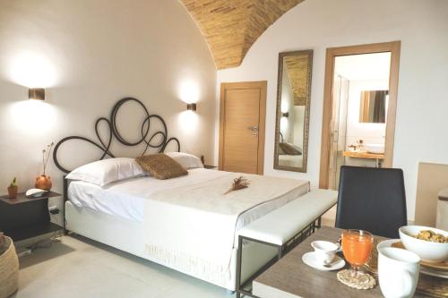 坎波马里诺Le Dimore del Borgo - Room & Breakfast的卧室配有一张白色的大床和一张桌子