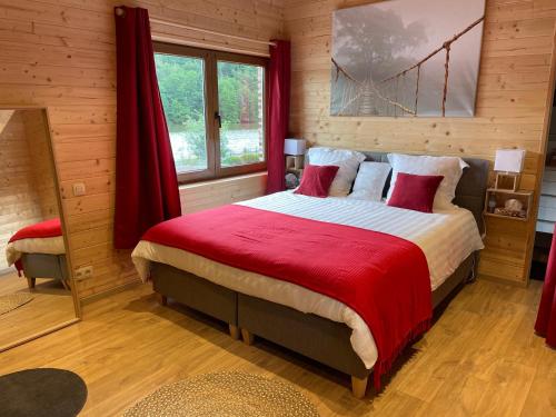 Hastière-par-delàLa Petite Maison au bord de l'eau的一间卧室配有一张带红色毯子的大床
