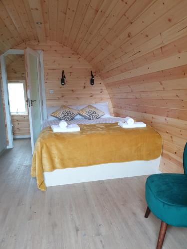 卡斯尔敦贝尔Berehaven Pods的木制客房内的一间卧室,配有一张床