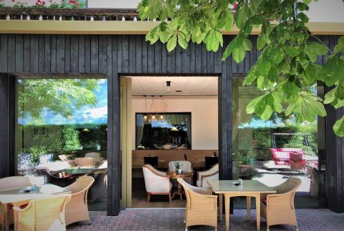 坎波迪特伦斯Hotel Residence der bircher的餐厅设有桌椅和大窗户。