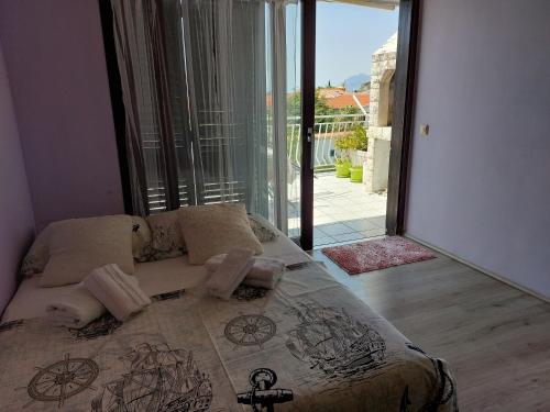 巴什卡沃达Apartmani Zuzana,Baška Voda的一间卧室设有一张床,享有阳台的景色