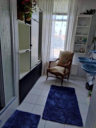 瓦瑟纳尔Cosy appartement Wassenaar的一间带椅子和水槽的浴室