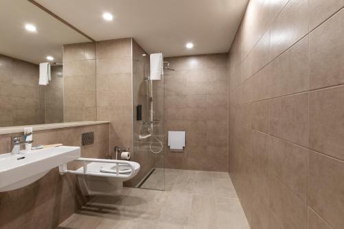 奥夫特林根B&B HOTEL Oftringen的浴室配有卫生间、盥洗盆和淋浴。