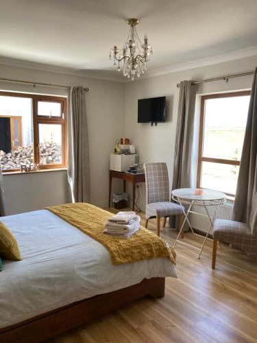 贝尔马利特Broadhaven Bay View Private House的卧室配有一张床和一张桌子及椅子