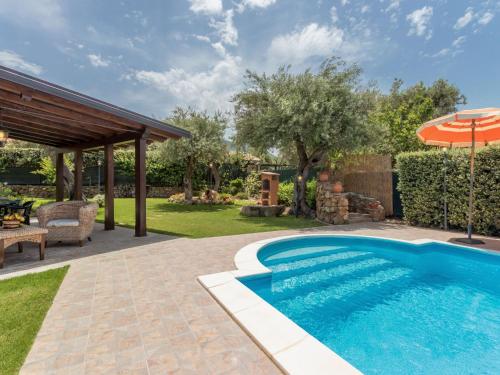 拉斯卡里Villa Jancaliva by Interhome的一个带遮阳伞的庭院内的游泳池