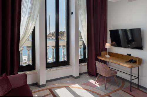 马卡尔斯卡Heritage Hotel Porin Makarska的客房设有书桌、电视和窗户。
