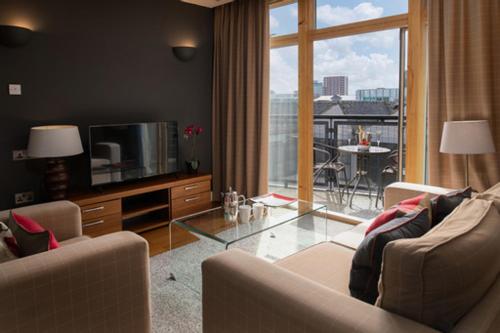 利兹尚波斯酒店的带沙发和玻璃桌的客厅