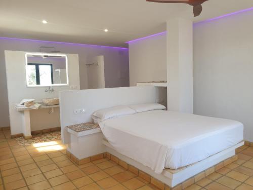 拉梅特拉·德·玛尔Masia La Candelera的卧室配有白色的床和镜子