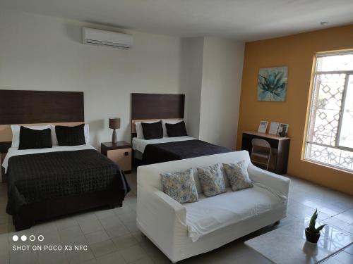 托雷翁Hotel del Bosque的酒店客房,设有两张床和一张沙发