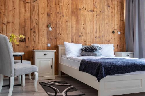 韦切什Airport Wanderer Inn - Vándor fogadó的一间卧室配有一张木墙床