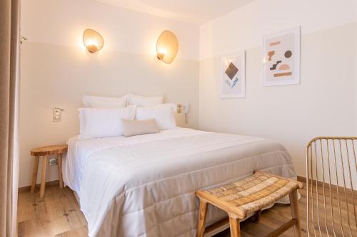 圣弗洛朗Hôtel Flor的卧室配有一张白色大床和一把椅子