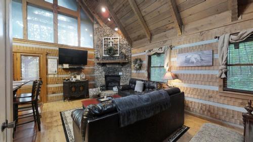 汤森德Blessed Nest Cabin的客厅设有真皮沙发和壁炉