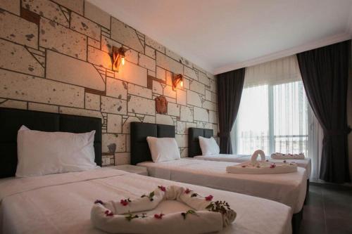 古穆杜尔Lebedos Apart Hotel的酒店客房,配有两张带鲜花的床