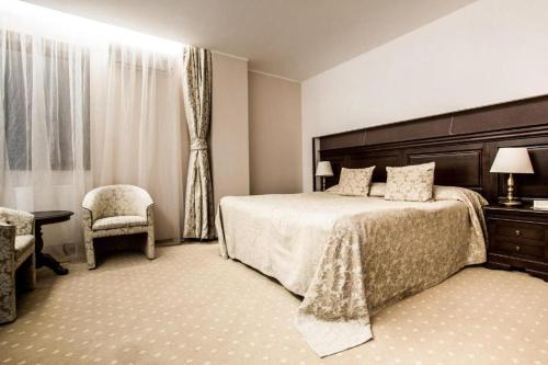 波亚纳布拉索夫Alpin Resort Hotel - Apartamentele 2403-2404- proprietate administrata de gazda privata的一间卧室配有一张大床和一把椅子