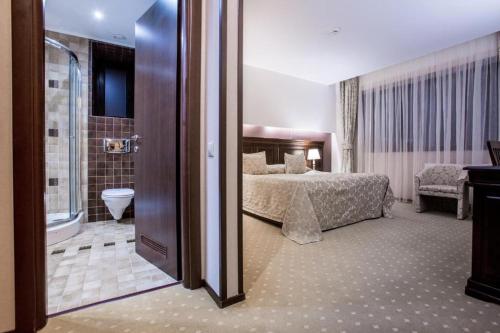 波亚纳布拉索夫Alpin Resort Hotel - Apartamentele 2403-2404- proprietate administrata de gazda privata的一间卧室配有一张床,浴室设有淋浴。