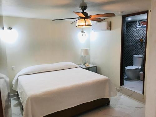 马萨特兰Hosteleria Casa Margarita的一间卧室配有一张床和吊扇
