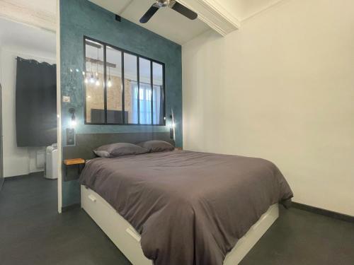 格拉斯L'Atelier de l'Amiral - Parking - Centre Historique的一间卧室设有一张大床和一个窗户。