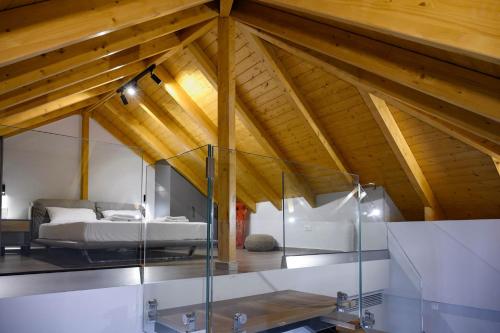 普雷韦扎Luxury Suites by Panagiota的客房位于带木制天花板的阁楼,配有一张床。
