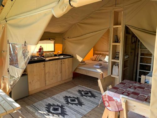 多尔盖罗Safari Tent with Hot Tub in heart of Snowdonia的帐篷,配有厨房和桌子