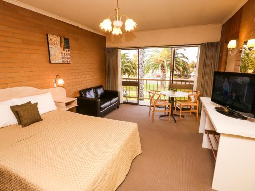 米尔迪拉米尔迪拉河城市汽车旅馆的酒店客房设有床、电视和桌子。