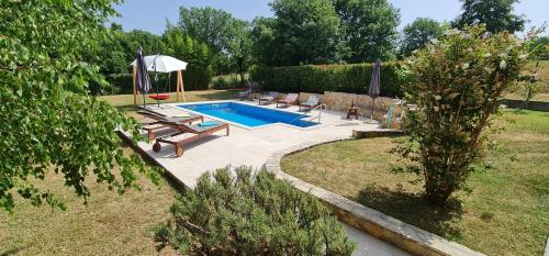 罗波里卡Sunny Garden Villa with Pool的庭院内一个带椅子和遮阳伞的游泳池