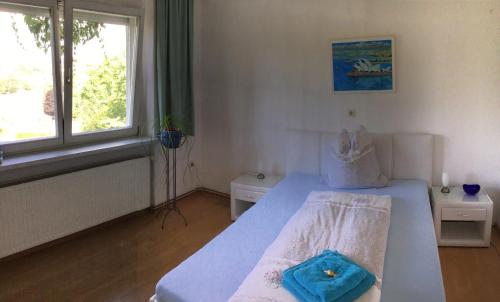 OberschützenFerienidylle Oberschützen的一间卧室配有一张带蓝色毛巾的床