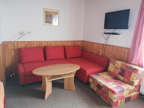 斯皮卡克Ubytování Maxa的客厅配有红色的沙发和桌子