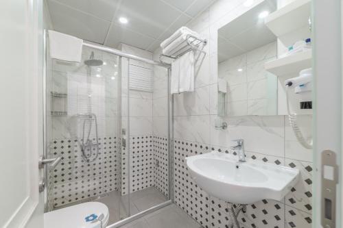安塔利亚DAM HOTEL LARA的白色的浴室设有水槽和淋浴。