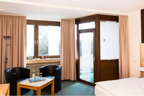 尼德根蓉北酒店的酒店客房带一张床、一张桌子和椅子