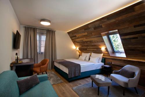 普利特维采湖B&B Plitvice Holiday Lodge的酒店客房,配有一张床和两把椅子