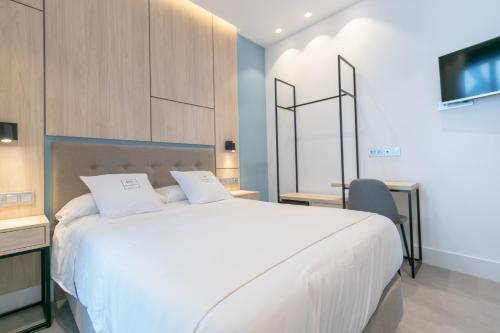 马拉加Real Maqueda - Málaga的卧室配有一张白色大床和电视。