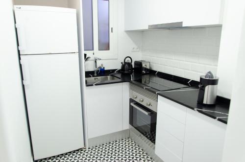 巴塞罗那Apartamento NUEVO con encanto en SAGRADA FAMILIA的白色的厨房配有冰箱和水槽