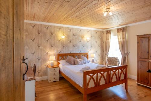KidwellyThe Coal House的一间卧室设有一张床和木制天花板