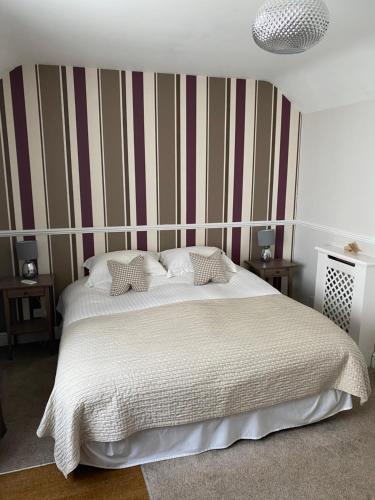 克莱尔船舶商店酒店的卧室配有一张白色大床和条纹墙