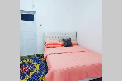 井里汶Stay@Pitaloka的一间小卧室,配有一张带粉红色床单的床