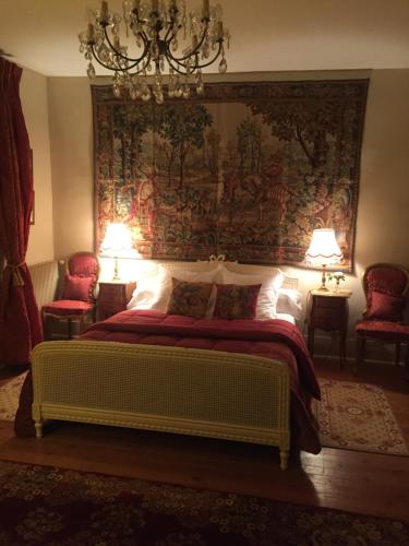 圣利斯Château Ratou的卧室配有一张挂壁挂毯的床