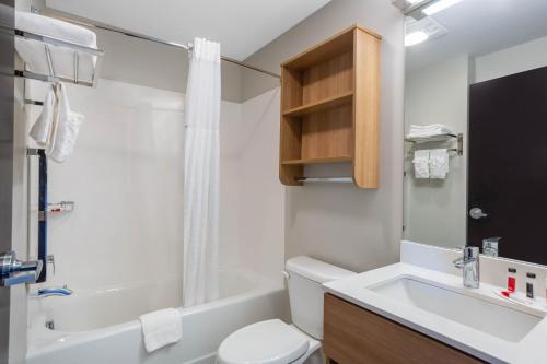 南希尔Microtel Inn Suites by Wyndham South Hill的浴室配有盥洗盆、卫生间和浴缸。