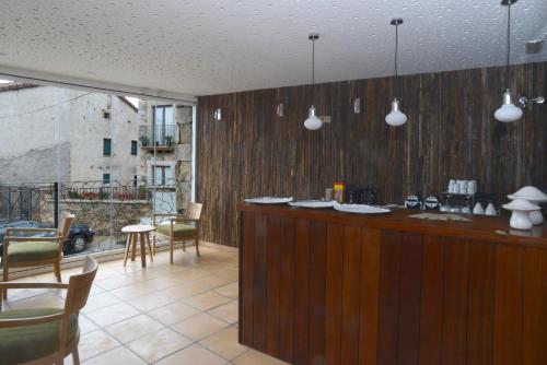 Garganta de los MontesHotel Rural Quercus Tierra的带椅子酒吧和阳台的厨房
